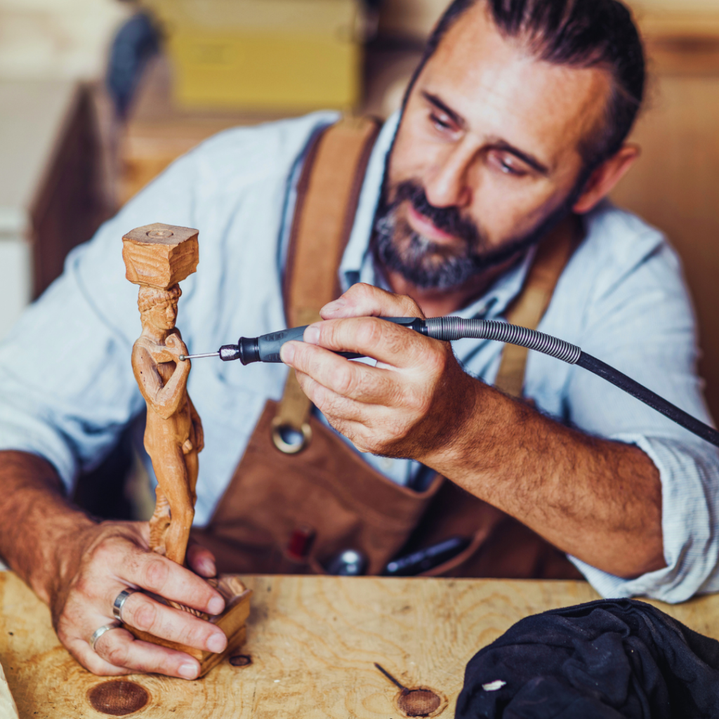 A senior experienced carpenter deep in his work of crafting custom beautiful immaculate wooden figurines