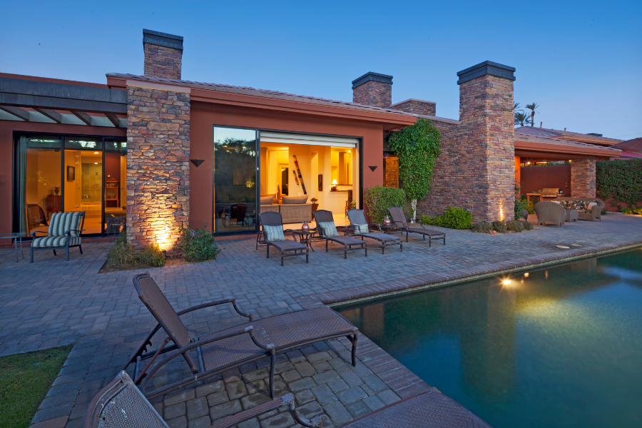 the exterior of a villa with a swimming pool, brick exterior and a nice quiet sitting area beside the pool